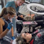 Cara with a live model and student during an SPMU training course.