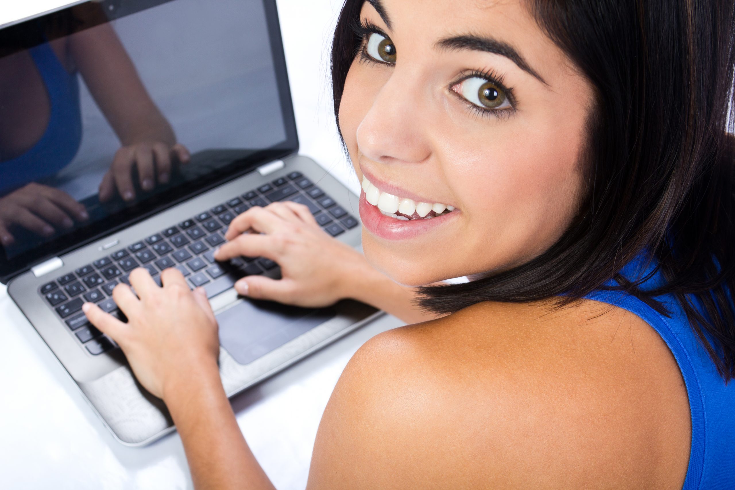 A smiling female student on her laptop about to start her SPMU Certified Online Course.