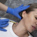 A woman receiving polynucleotide injectable treatment in her neck.