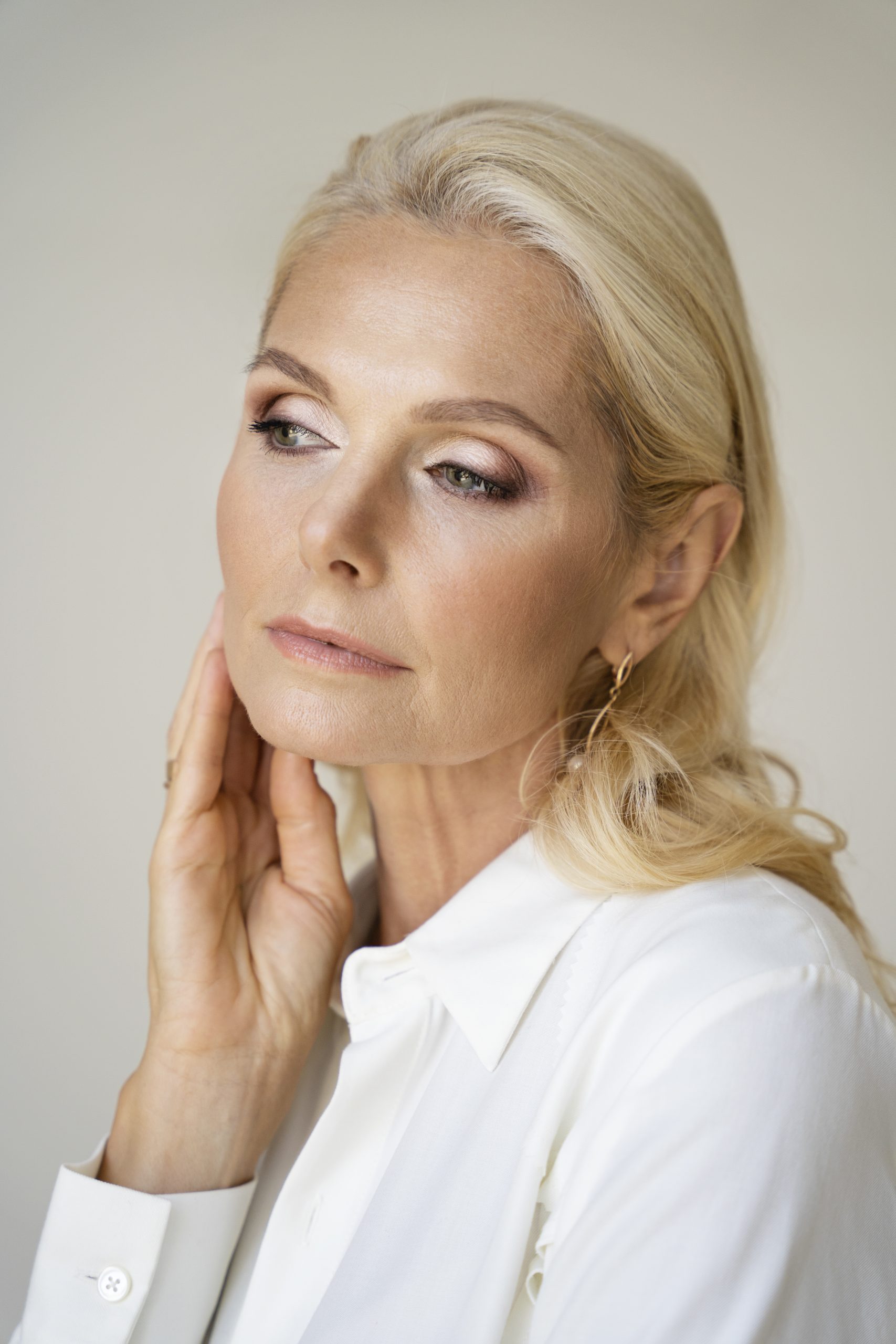 A middle-aged blonde woman who has maintained SPMU longevity.