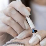 The trainee is performing a Microblading procedure on a client.