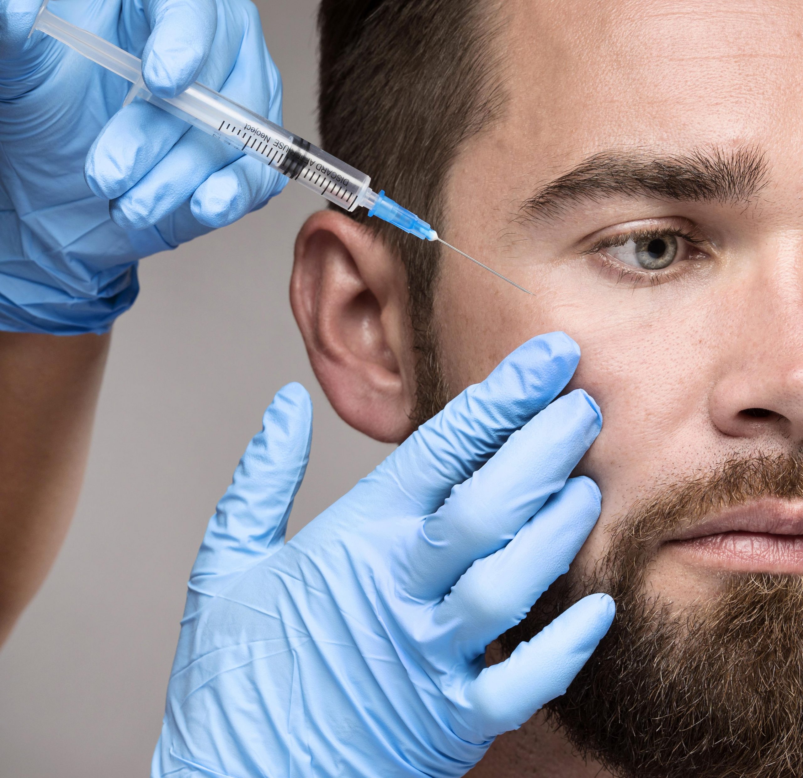 Close-up of a man being injected in his face.