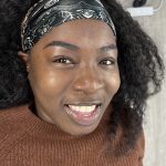 Portrait of a young smiling female black woman after Ombré Brows treatment.