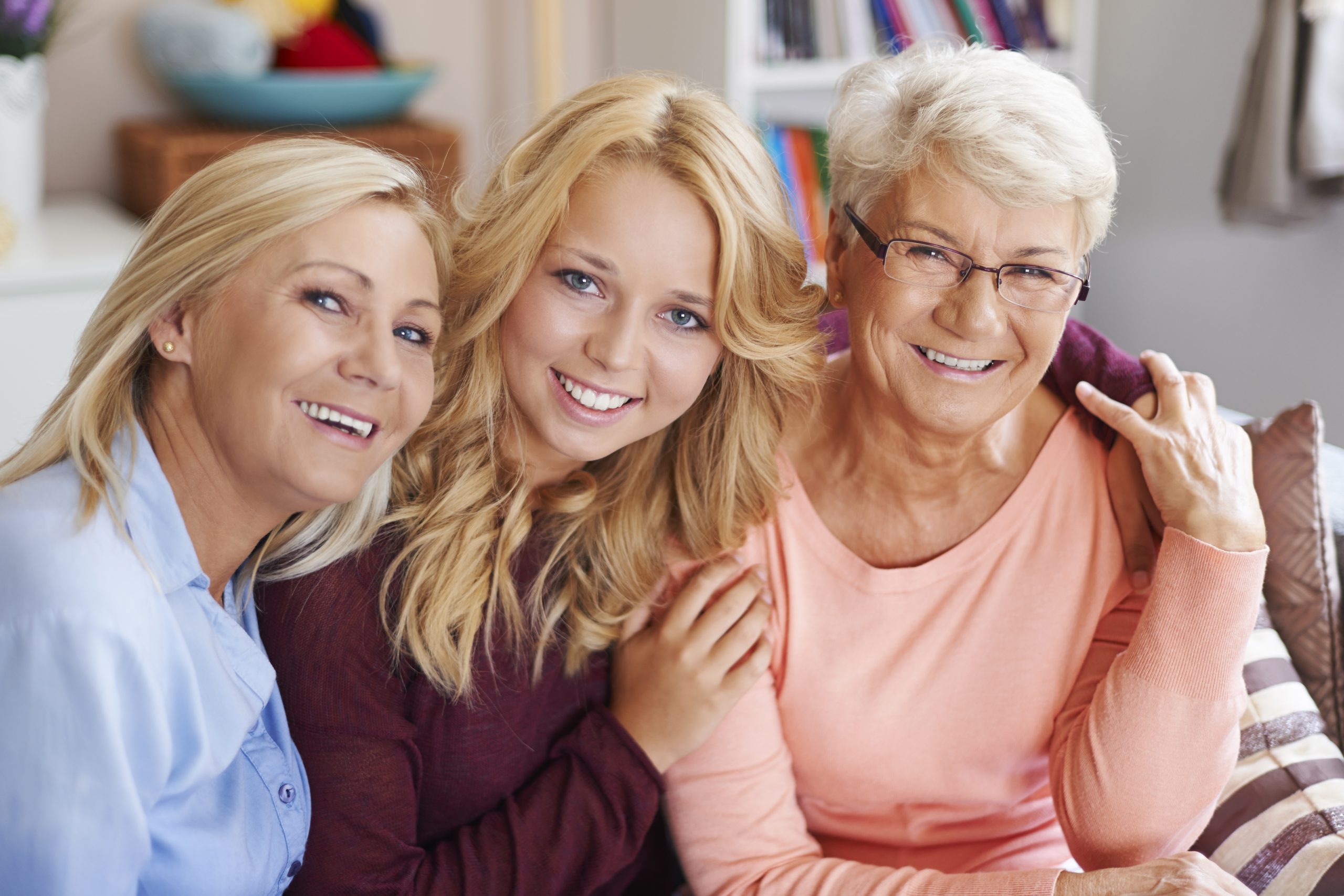 3 smiling female family members representing distinct generations.